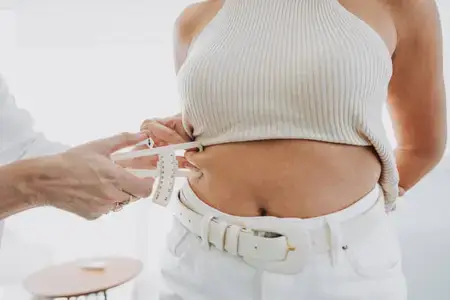 doctor-measuring-woman-belly-fat-in-clinic