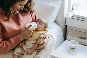 A mother feeding a baby with a baby bottle