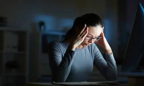 A stressed woman sitting in a dark room