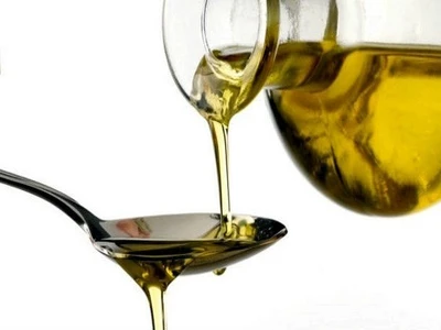 pouring virgin olive oil from bottle to a spoon