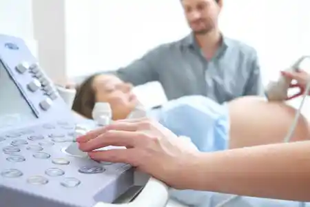 A lady doctor examining sonography of a pregnant woman