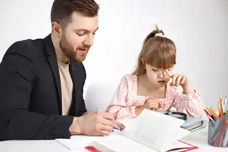 Good parenting skills dad helping his girl child in school homework