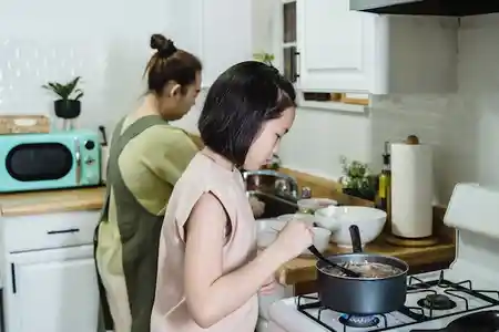 Good parenting skills girl helping her mother in kitchen