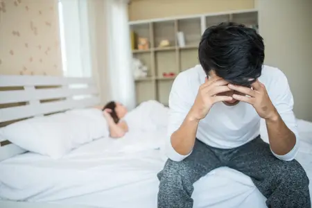 Man suffering from erectile dysfunction sitting on the bed depressed
