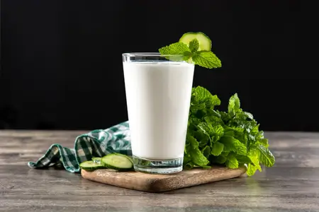 butter milk drink in glass with mint on wooden