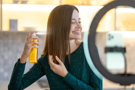 woman applying hair moisturizer on hair styling