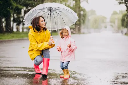 mother with daughter walking in rain