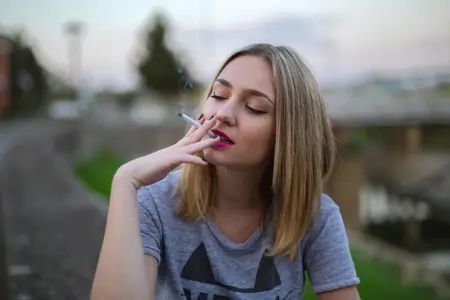 young-blonde-female-smoking-sitting-on-the-road