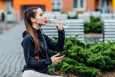 pretty-woman-drinking-water-outdoors-in-summer-day